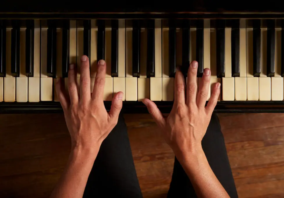 Closeup of female hands playing the piano, view from the top